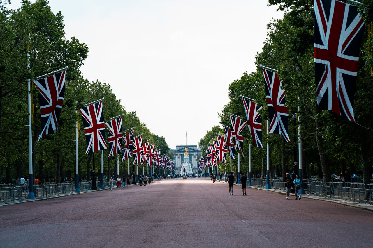 The Mall in London decorated with British flags, leading to Buckingham Palace.